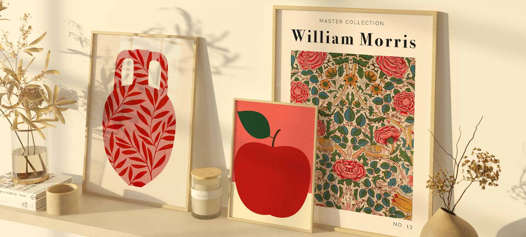 A harmonious composition of three framed posters: a William Morris exhibition poster, a stylised vase with leaves, and a minimalist apple