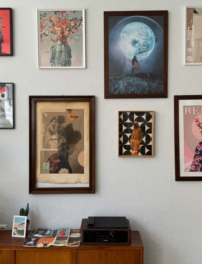 Framed artworks on a white wall with an audio device on a sideboard below Framed artworks on a white wall with an audio device on a sideboard below