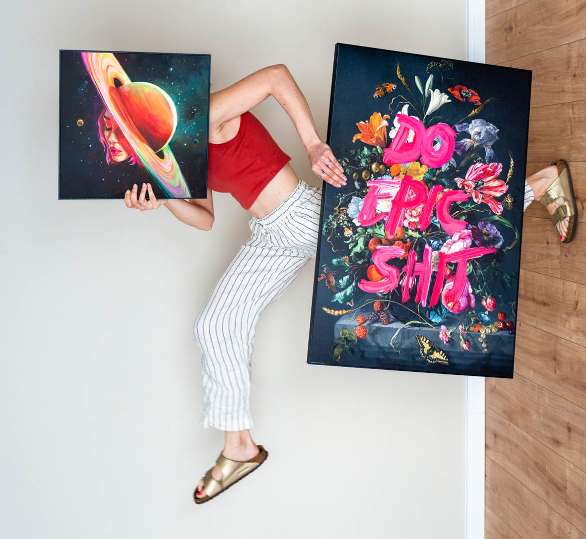 A person carrying two colourful wall art prints
