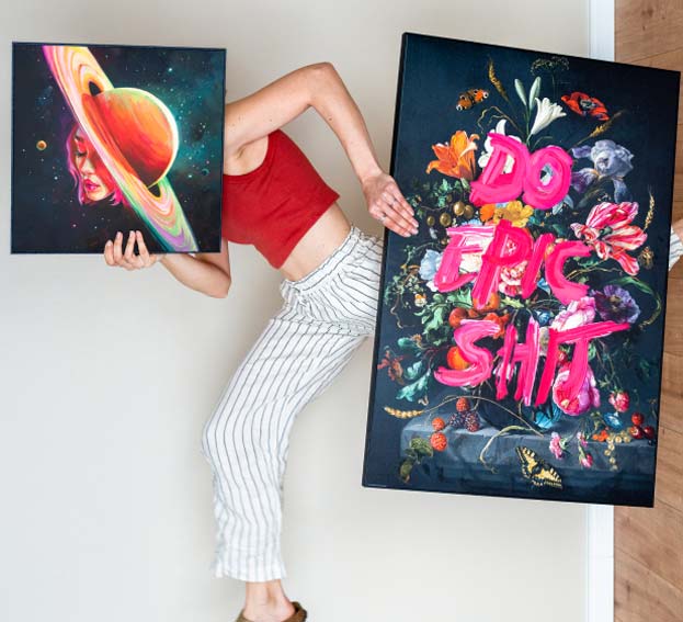 A person carrying two colourful wall art prints